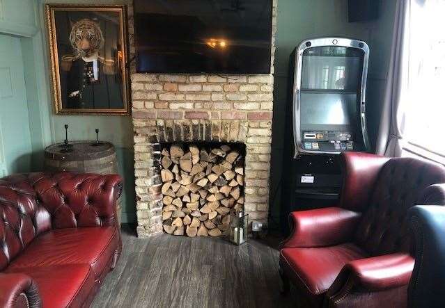 The front bar, with logs stacked in the fireplace, is furnished with chairs and sofas which look as if you’d sink into them